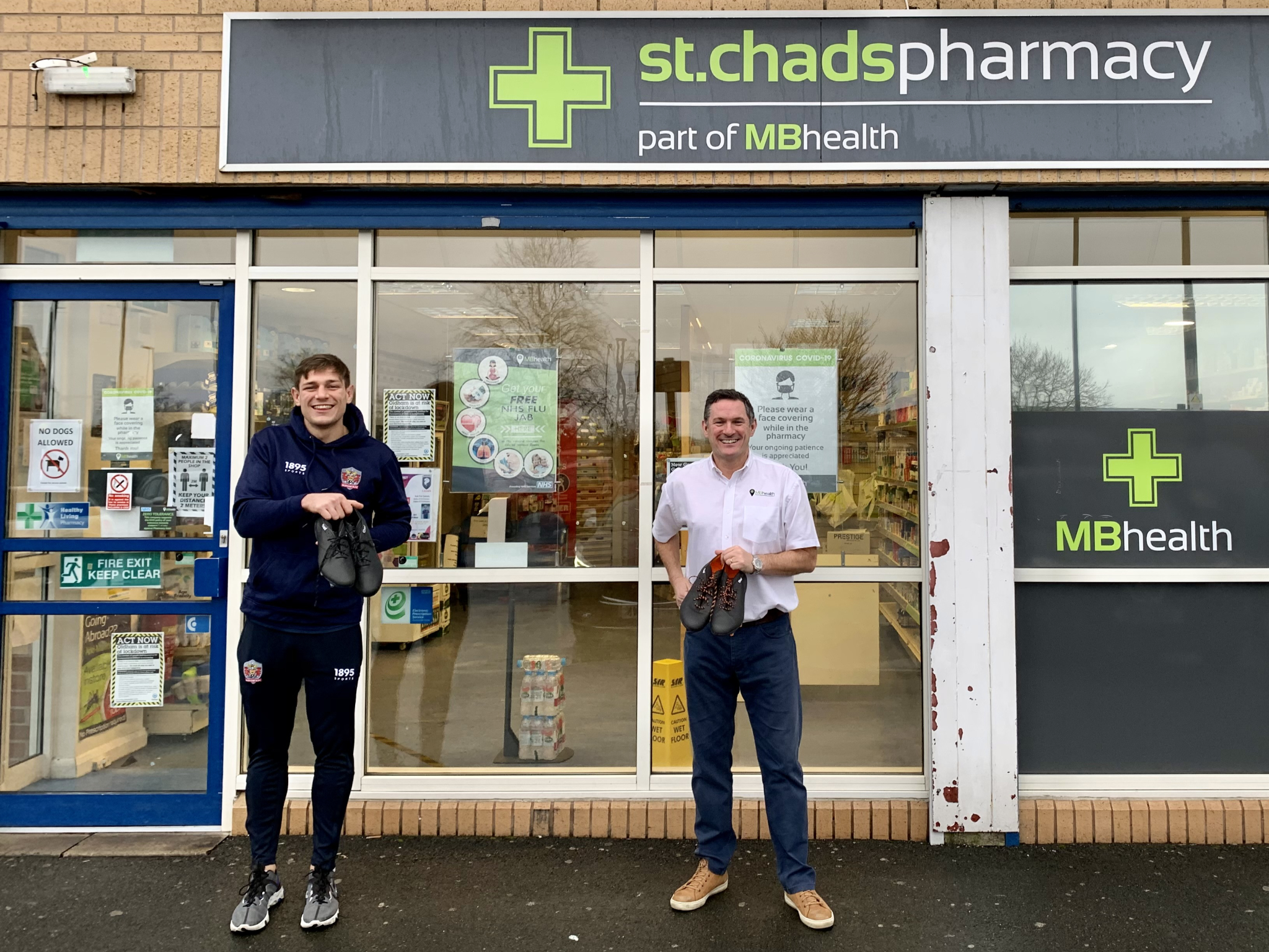 Liam Bent (left) and Martin Molyneux, of St Chad’s pharmacy, showing off the boots outside the Lime Green Parade store.